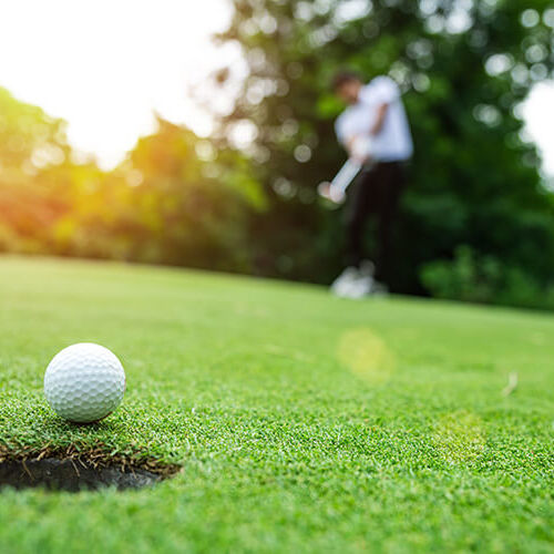 golfer putting ball into hole